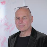 Headshot of Charles Zuker, PhD with glasses propped up