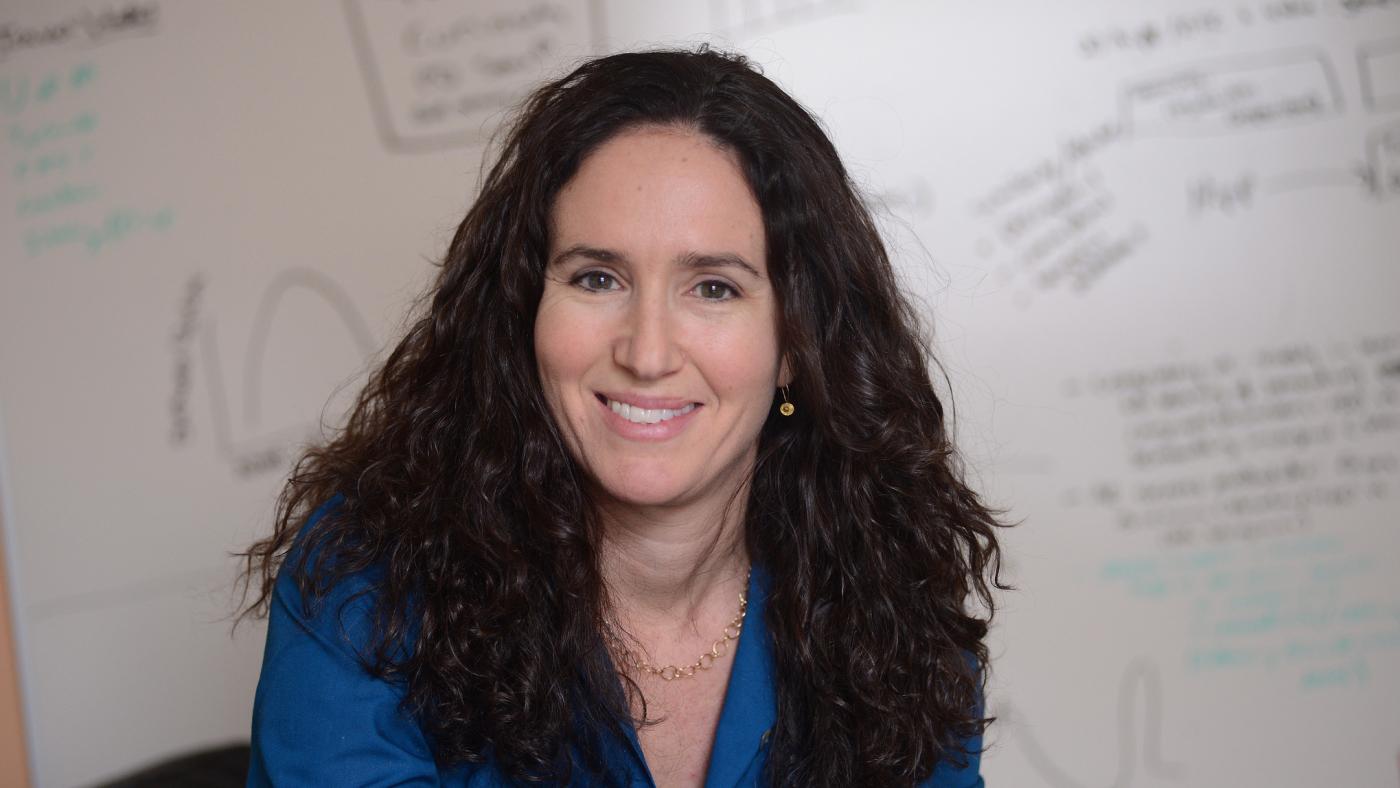 Daphna Shohamy, PhD in front of white board with equations